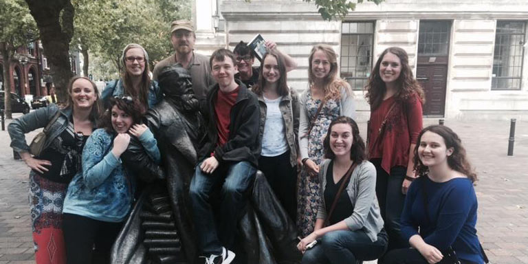 Students pose with statue in London